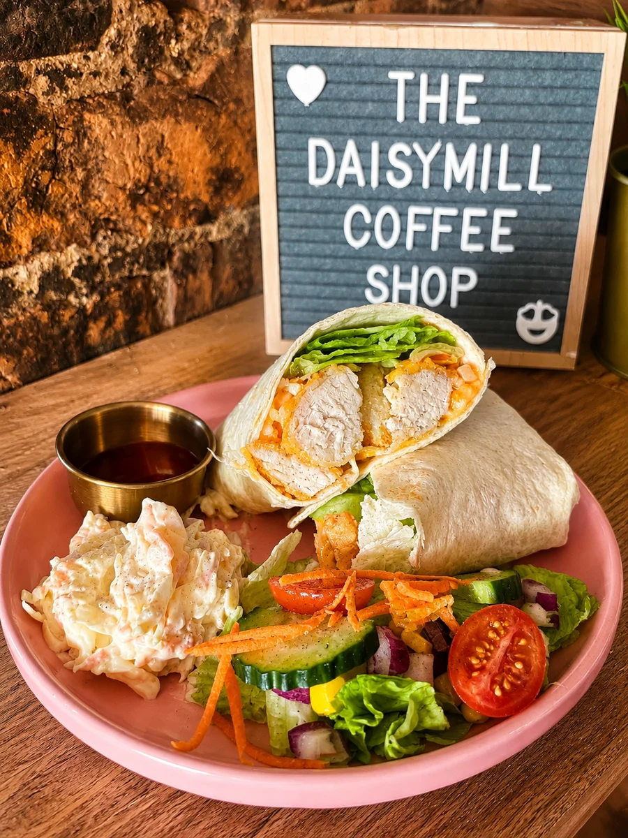 Chicken wrap served with salad on a pink plate